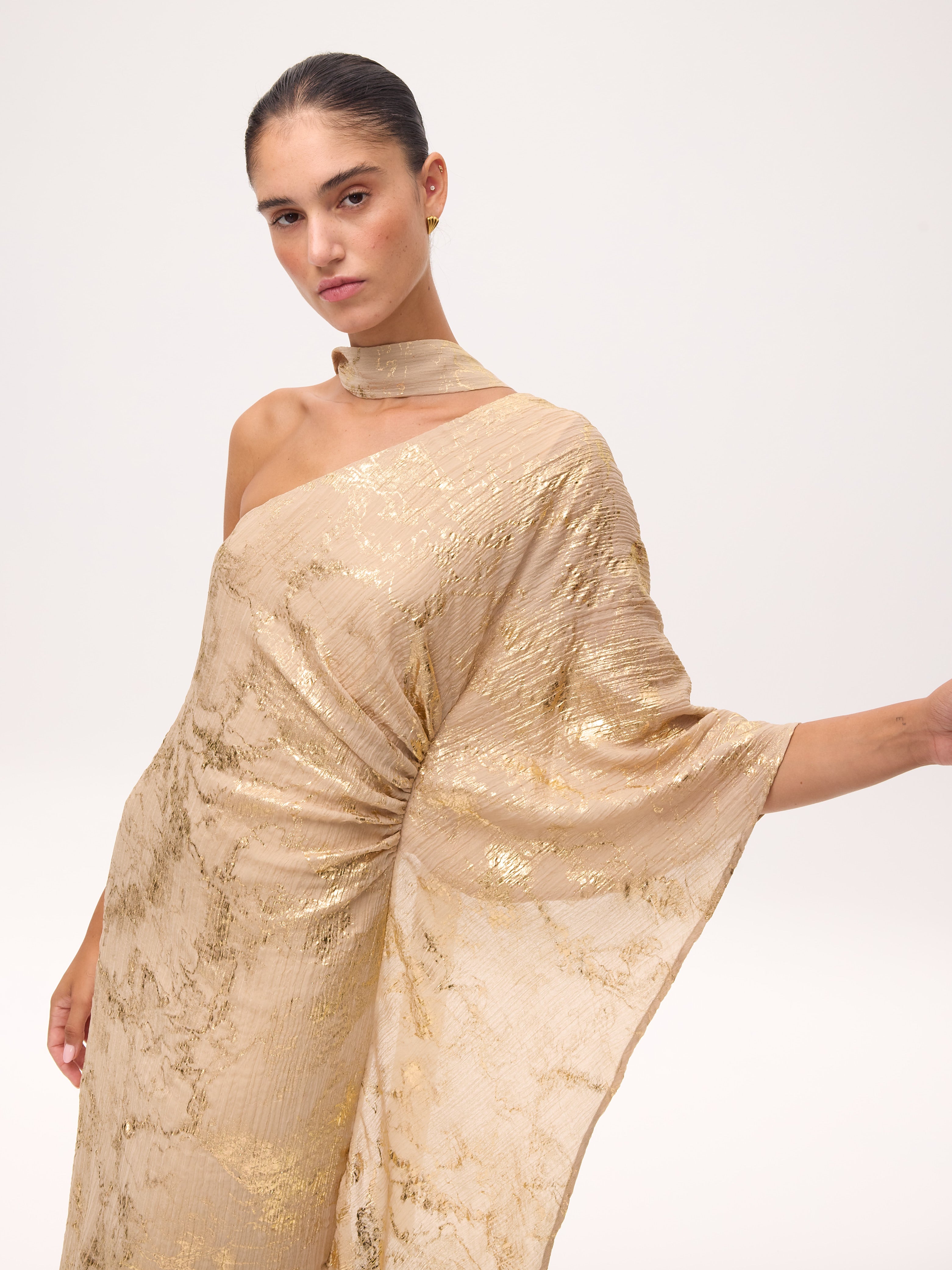 AARON - Vestido asimétrico manga capa nude con lurex, perfecto para invitadas de boda y fiesta spring summer. MIOH es la marca de vestidos de invitada de boda y fiesta de referencia en España