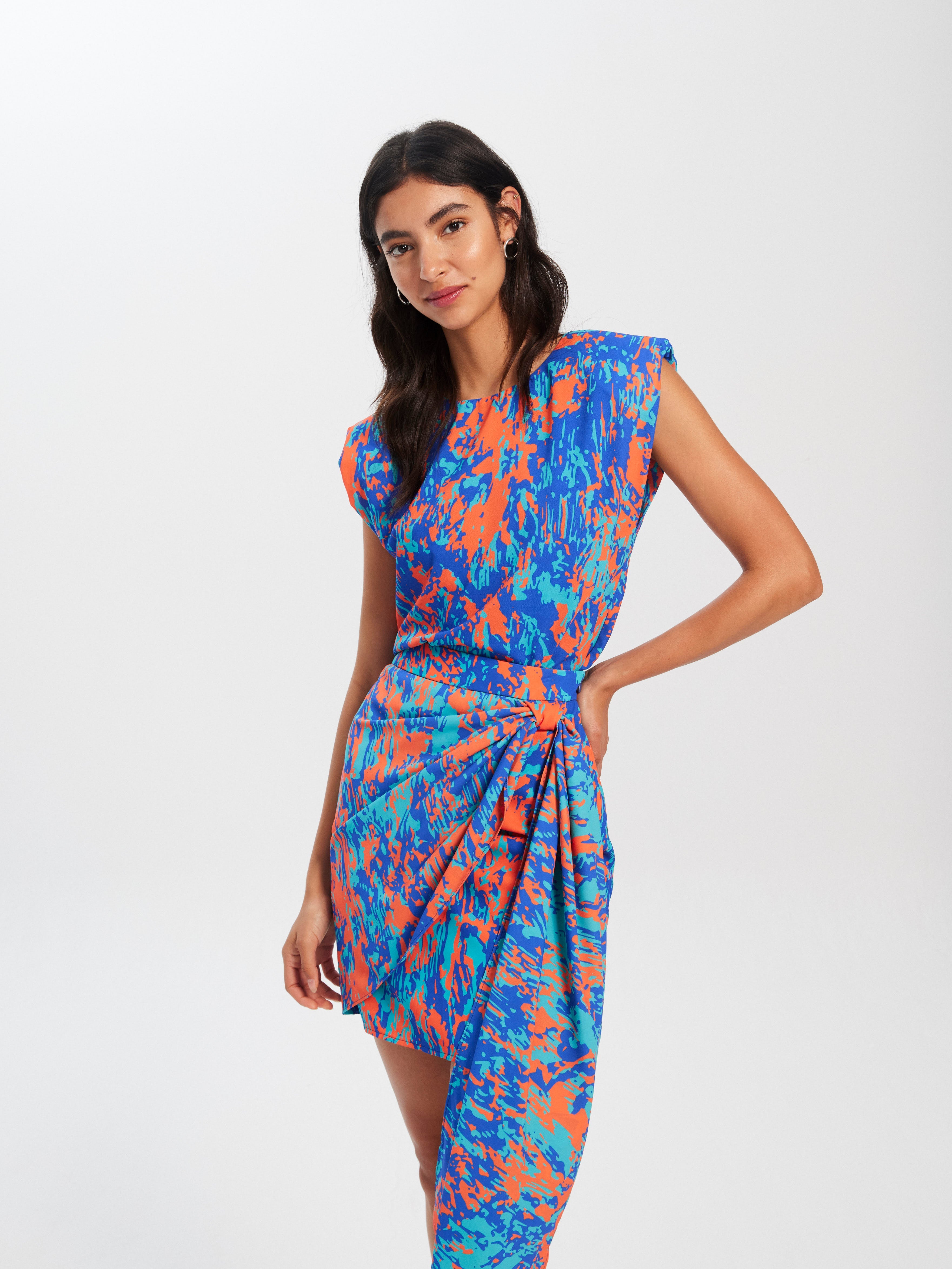 mioh | CLARA SKIRT PAINT - Conjunto de top sin mangas con maxi hombrera y falda corta con lazada para ser la invitada de boda perfecta esta temporada Primavera Verano 2023. Los conjuntos de top y falda son pura tendencia SS23 y una de las señas de identidad de MIOH, la marca española de vestidos de invitada de boda favorita de las influencers