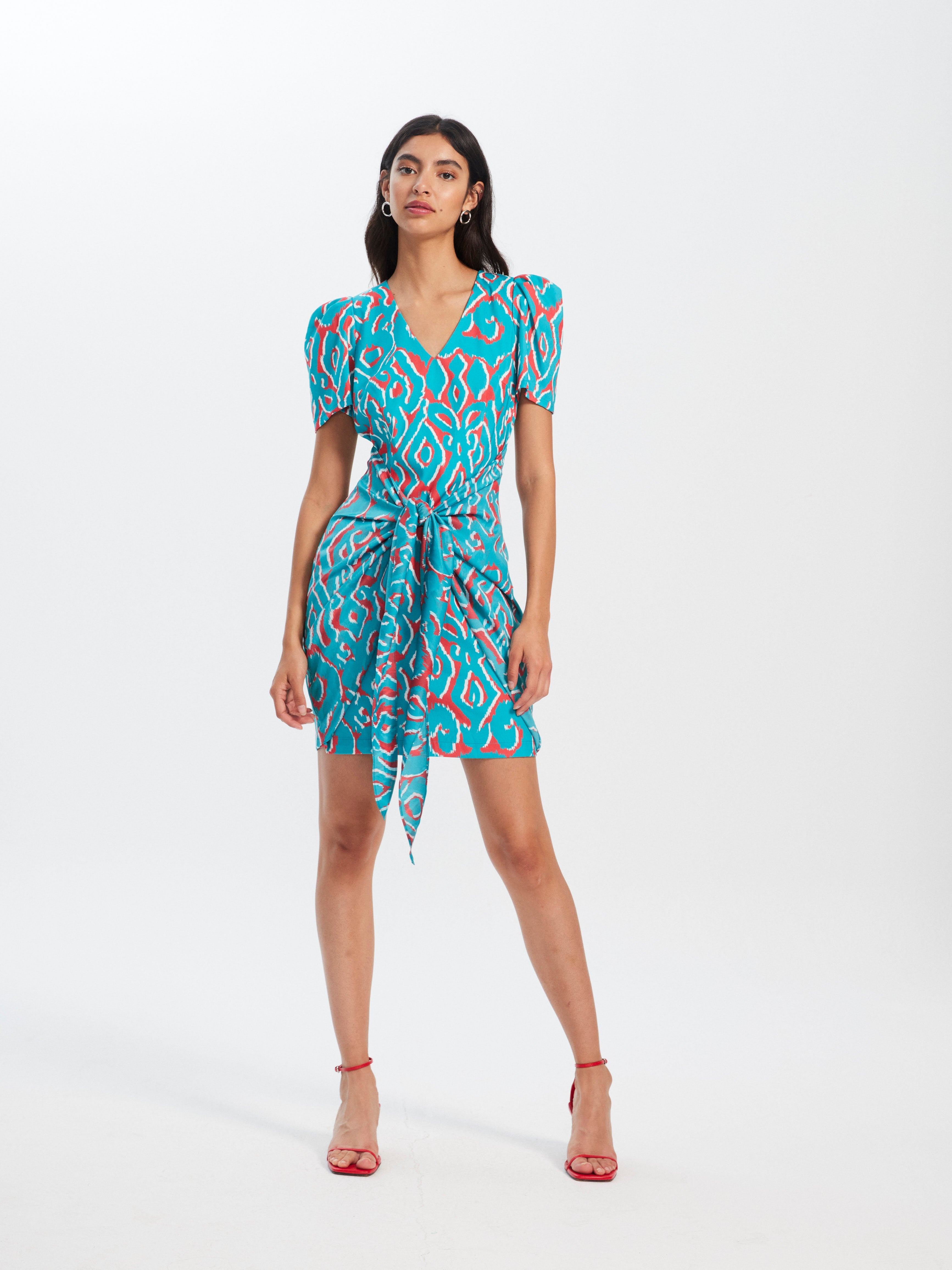 mioh | JULIETA IKAT - Vestido corto invitada boda, fiesta y evento. Vestido corto de fiesta con manga corta y lazada para ser la invitada de boda perfecta esta temporada Primavera Verano 2023. Los vestidos cortos con estampados llamativos son tendencia SS23 y una de las señas de identidad de MIOH, la marca española de vestidos de invitada de boda y fiesta.